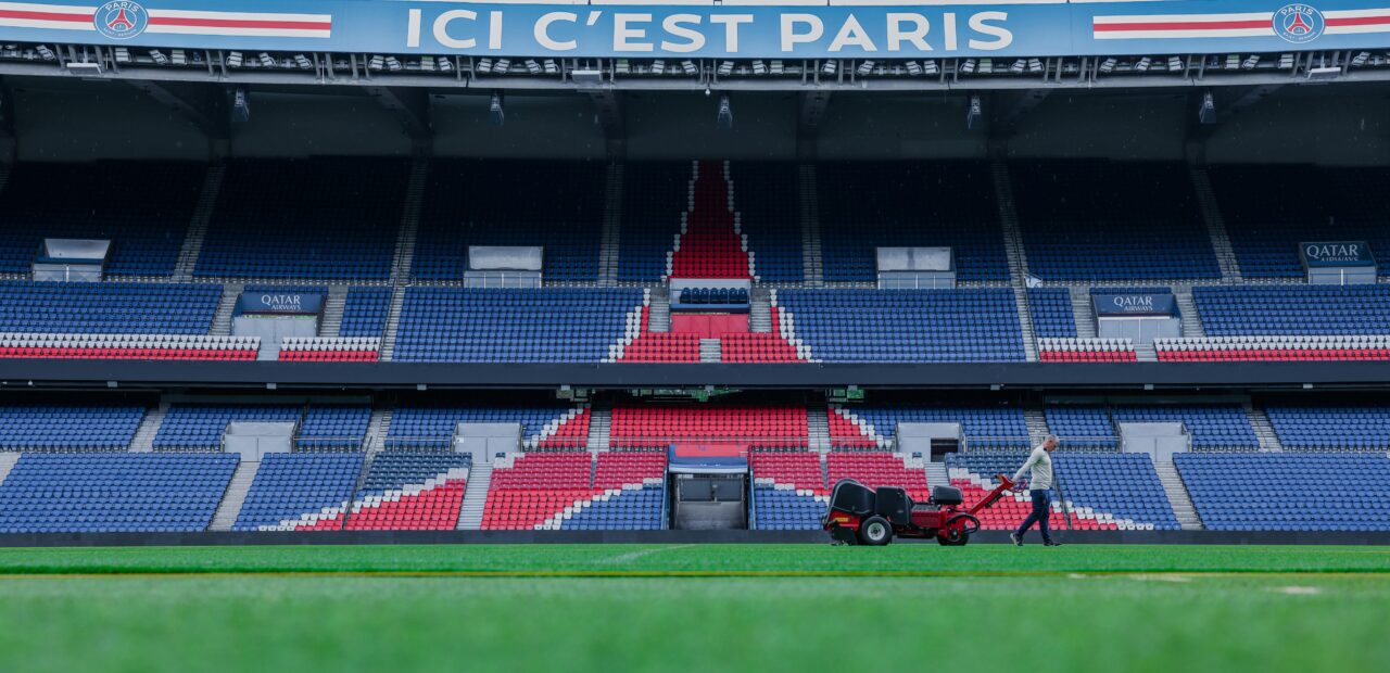 Gardener working on the field at Parc des Princes stadium, Paris. Vibrant and iconic sports venue.